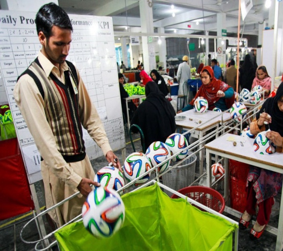 Photo (from the pamphlet, not a data chart): footballs being hand-stitched on a Sialkot sports-goods factory floor.